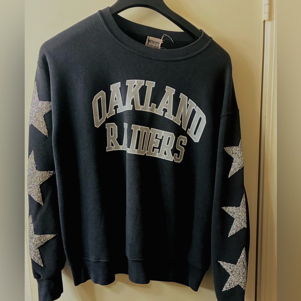 Oakland Raiders sweatshirt featuring star embellishments on the sleeves